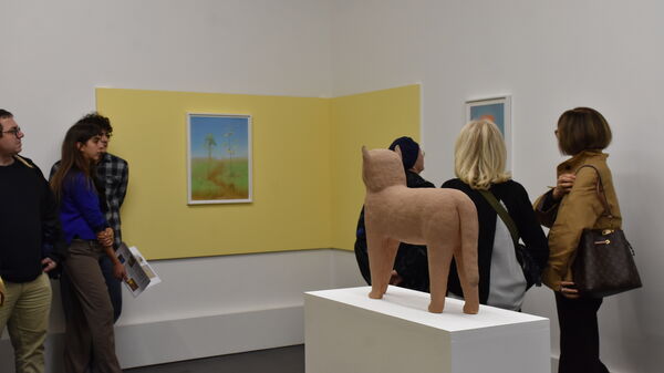 Six personnes découvrent la sculpture en grès Miaou et deux dessins de Corentin Grossmann dans la première salle de l'exposition Les animaux ne portente pas de chaussures.